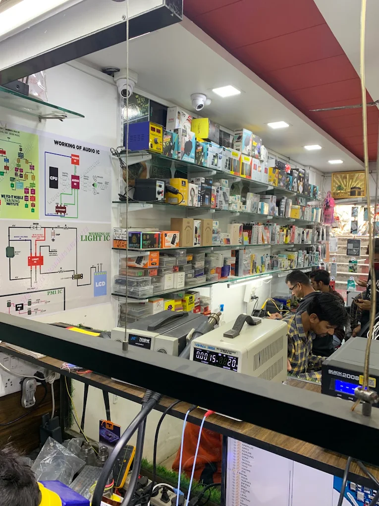 Technicians working at the repair counter beside audio IC and light IC circuit diagrams